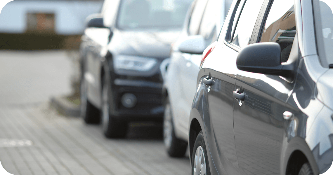 A row of parked cars along a paved street.